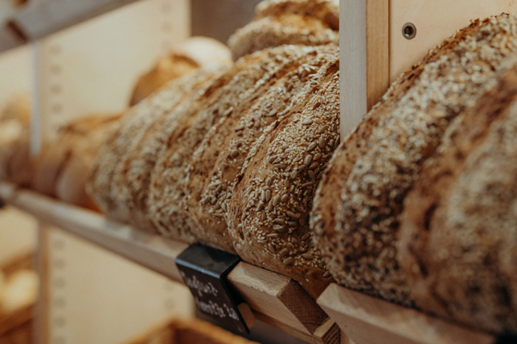 Frische Brote mit Körnern in der Brotauslage – Bäckerei Ostendorf