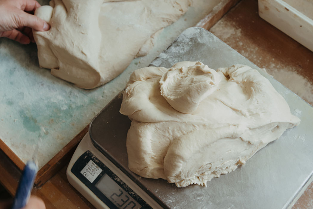 Handarbeit am frischen Brotteig auf der Waage – Bäckerei Ostendorf
